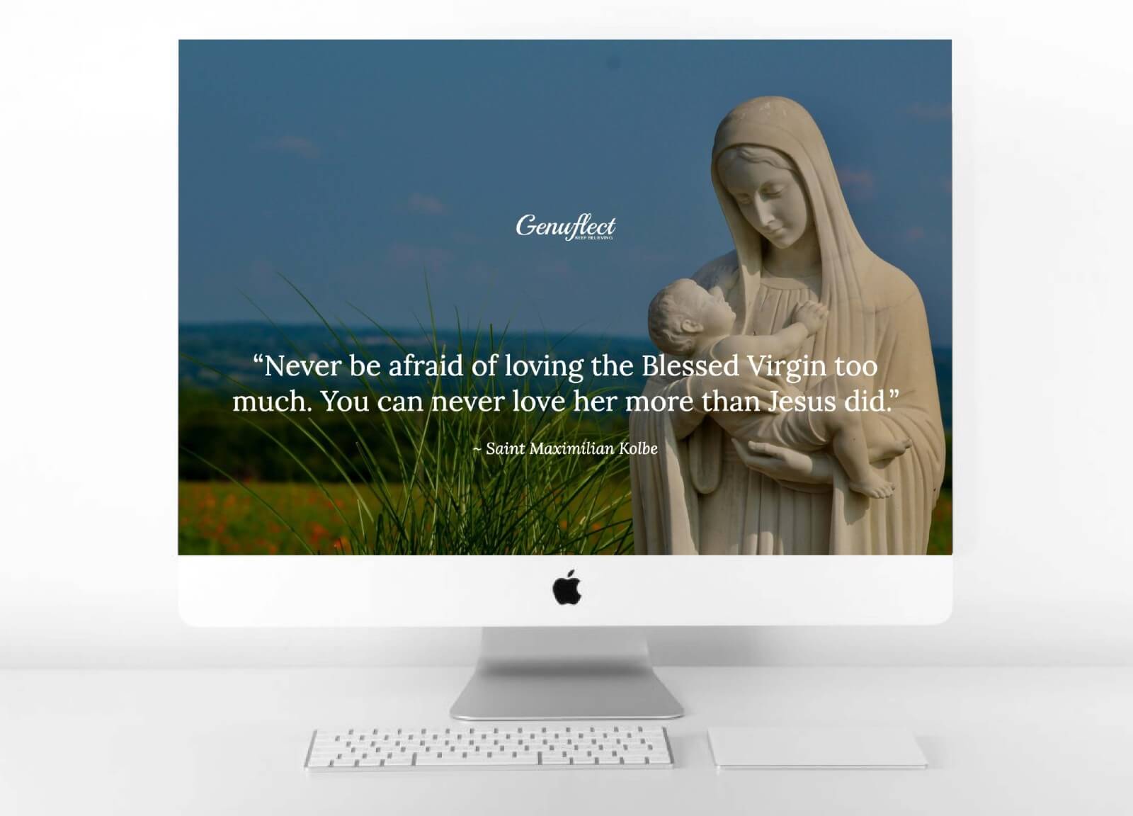 Genuflect computer background image of a Statue of the Blessed Virgin Mary holding the baby Jesus outside with the ocean in the background