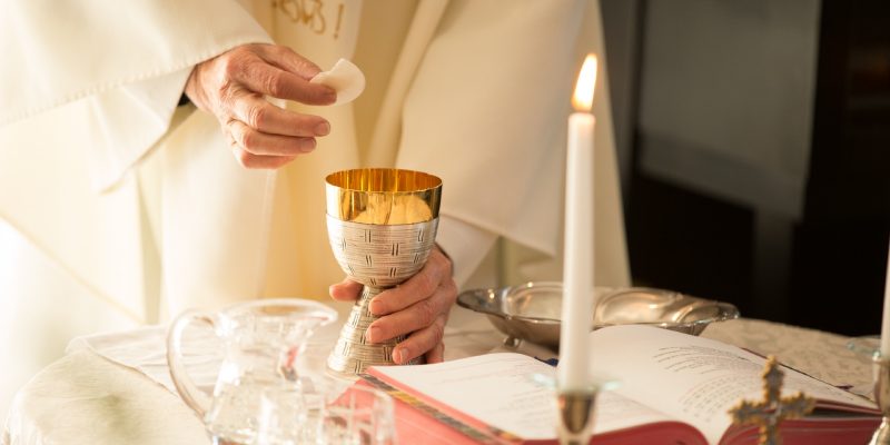 priest holding holy Communion