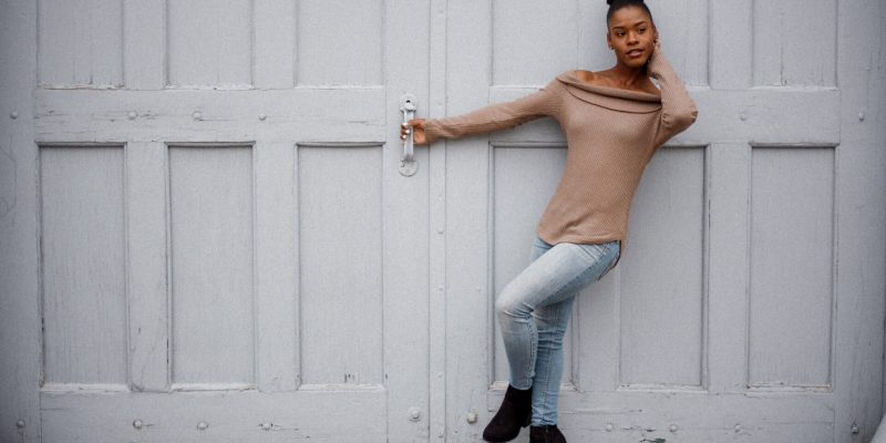 Woman in front of a white garage door holding on to the door handle