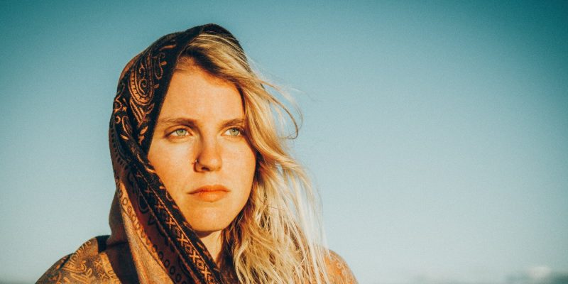 Close up of woman out in the desert with scarf around head and a serious look on her face