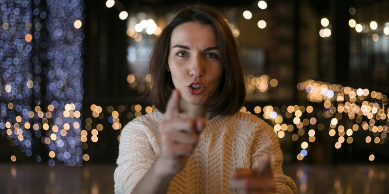 Woman facing camera and talking while pointing with her fingers