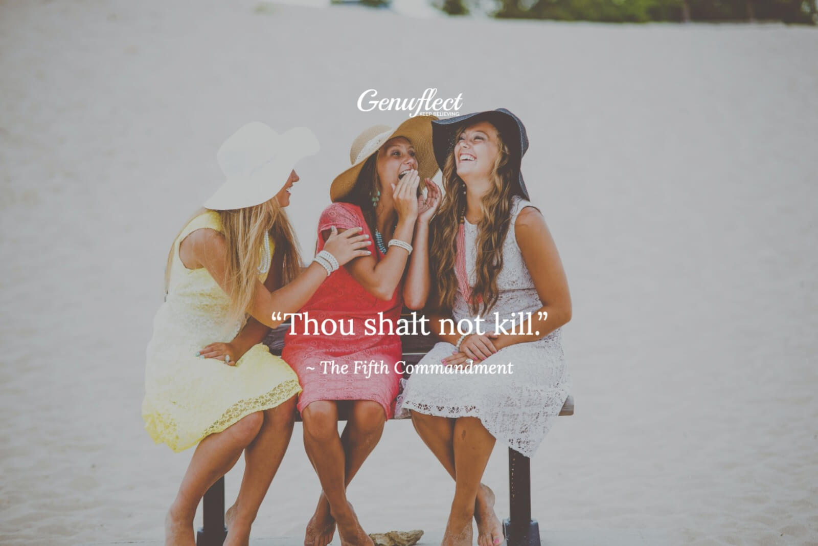 Three women sitting outside in the bright sun smiling and sharing secrets