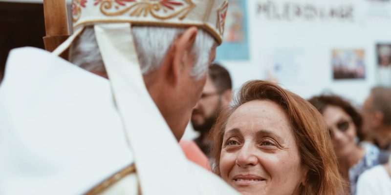 Woman talking to a Bishop with a smile on her face