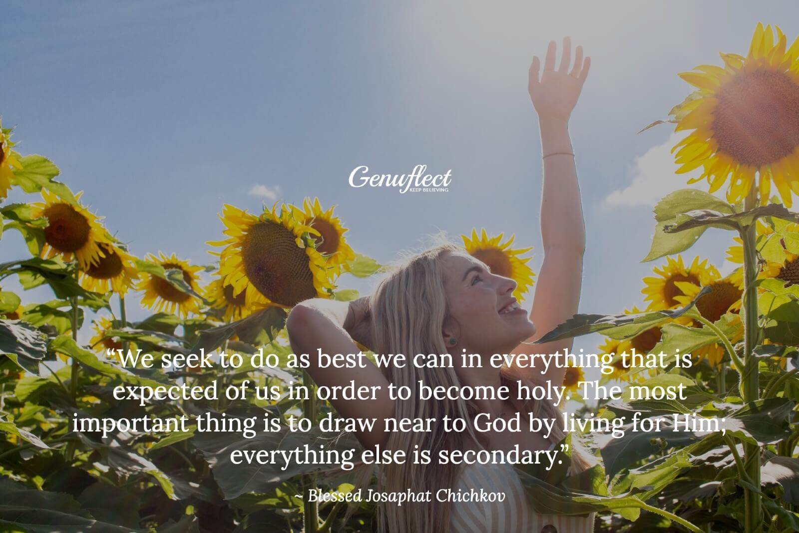 Woman standing in sunflower field looking up to the sky with arm reaching up