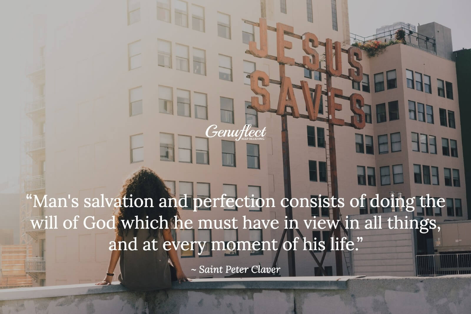 woman sitting on a wall looking up at a JESUS SAVES sign on a nearby building