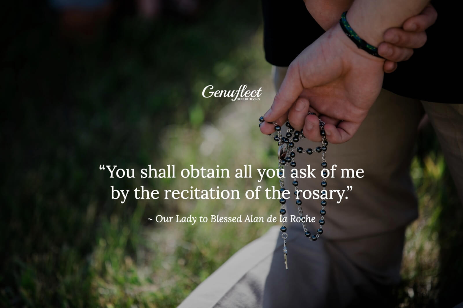 Close up of a man's hand holding a black rosary in prayer