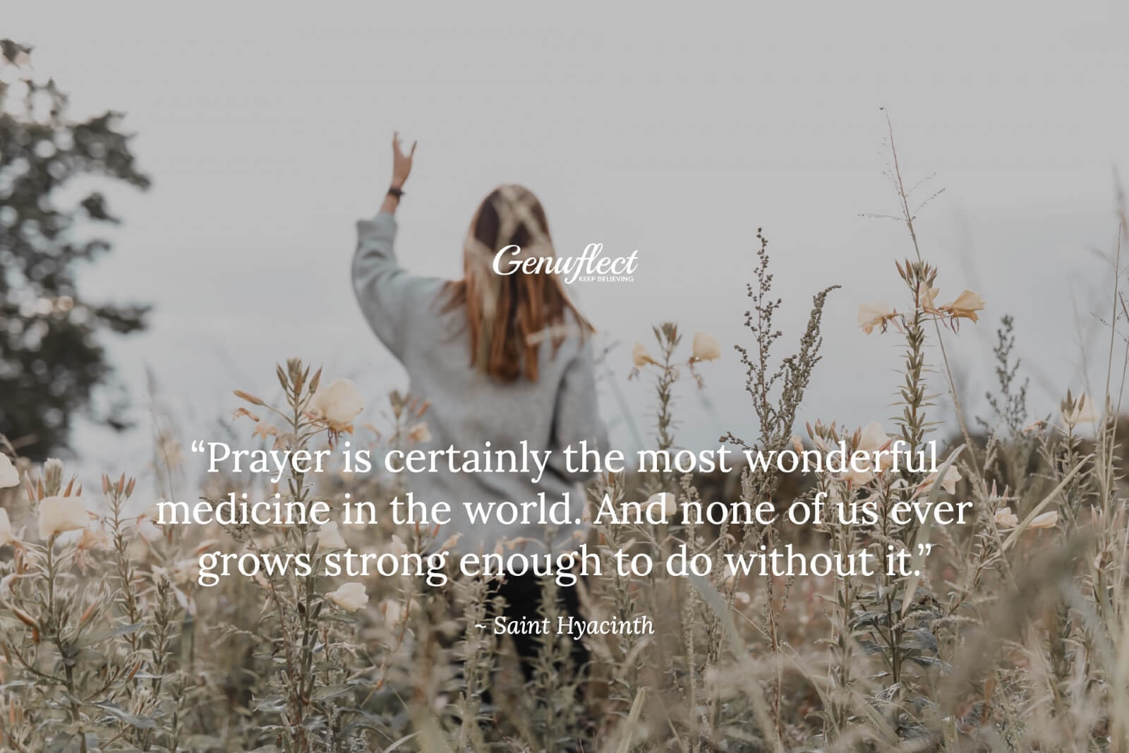 Woman outside standing in a field with an arm raised up to heaven