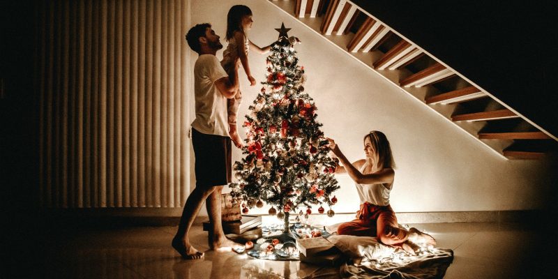 Genuflect - family decorating a Christmas tree