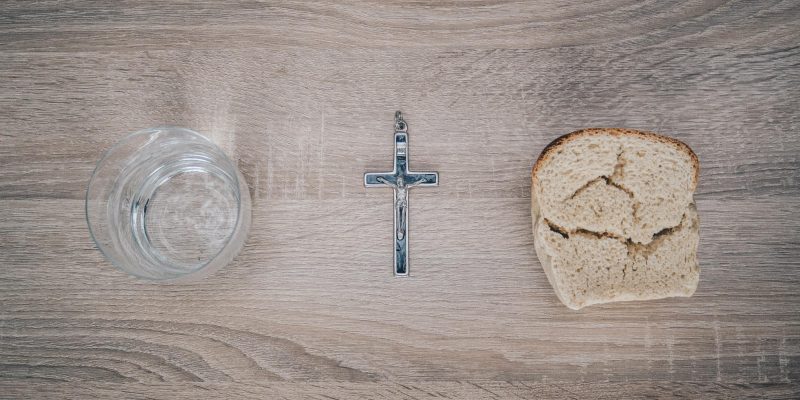 Water, bread, and a crucifix lying on a table