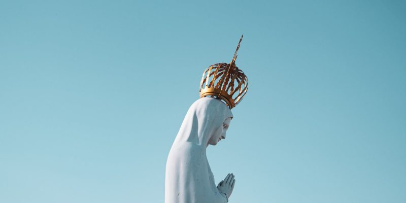 Side view of Our Lady of Fatima statue with blue sky in the background