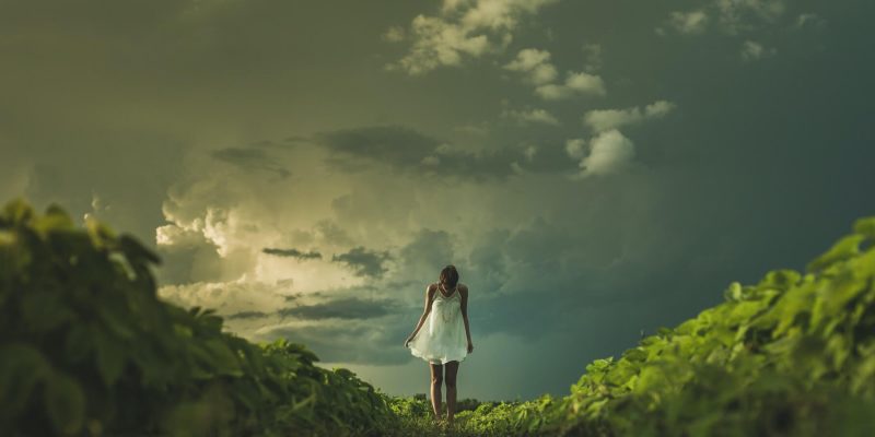 Woman standing outside under storm clouds
