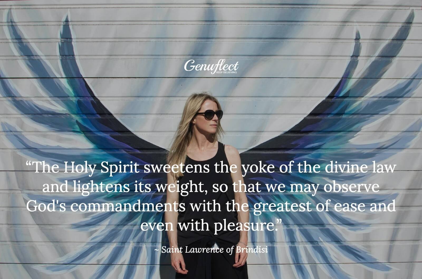 Woman standing in front of a wall with angel wings painted on it