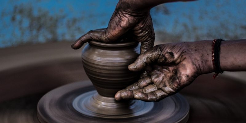 Close up of hands working with a pot on a potter's wheel